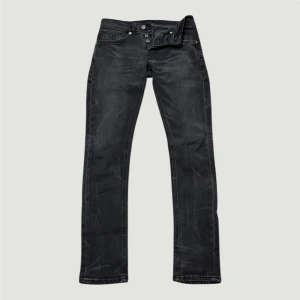 Svarta dondup george - Snygga svarta jeans från dondup med slim fit och klassisk femficksdesign. Jeansen har en diskret tvättad look, knappgylf och detaljerade bakfickor med broderad logga. Perfekta för dig som gillar stilrena och coola jeans. Jeansen har en cool selvedge tvätt.