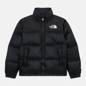 Svart pufferjacka från The North Face - Säljer en svart pufferjacka från The North Face med hög krage och dragkedja framtill. Jackan har två sidofickor med dragkedja och logga på bröstet. Perfekt för kalla dagar och riktigt skön att bära.