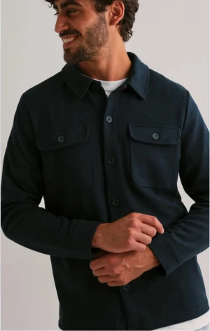 Svart skjorta från Only & Sons XS - Svart skjorta från Only & Sons i storlek XS. Klassisk design med två bröstfickor med knappar, krage och långa ärmar. Skjortan har en stilren look och är tillverkad i mjukt bomullsmaterial. Perfekt för dig som gillar enkel och clean stil.