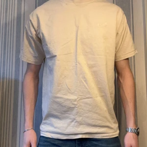 Beige Levi's t-shirt vintage fit - Säljer en beige t-shirt från Levi's med vintage fit. T-shirten har korta ärmar, rund hals och diskret broderad Levi's-logga på bröstet. Tillverkad i mjuk bomull som känns skön mot huden. Perfekt basic-plagg med clean look.