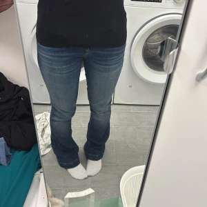 Blå bootcut jeans från LTB - Snygga blå jeans från LTB med bootcut passform och klassiska fickor både fram och bak. Jeansen har en mörk tvätt med lätt slitning och kontrastsömmar. Tillverkade i mjukt denim-material som sitter skönt och ger en schysst siluett. Storlek W25 L30