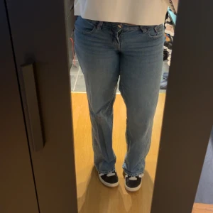 Blå raka jeans från Gina tricot - Säljer ett par klassiska blå jeans från Gina tricot i storlek 38. Modellen har wide passform med ultra low waist midja och fem fickor. Jeansen är tillverkade i mjukt denimtyg och har snygga kontrastsömmar. Perfekt för dig som gillar en enkel och tidlös look.