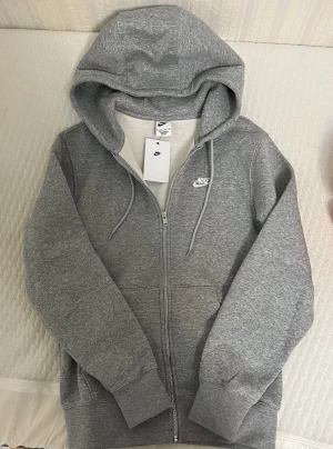 Nike Hoodie - Jag säljer en helt ny Nike Hoodie med luva och dragkedja i storlek XS. Köpt ifrån Unisport.se men det var fel storlek och dem accepterade inte returen. Helt ny endast testad 1 gång!
