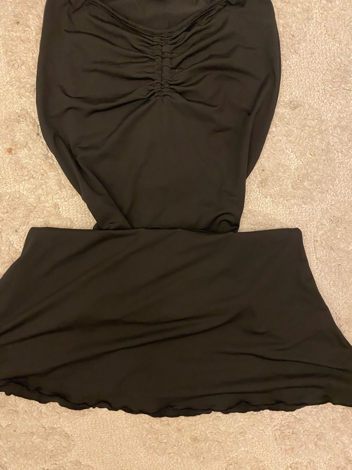 Svart kortkjol med rynkdetalj