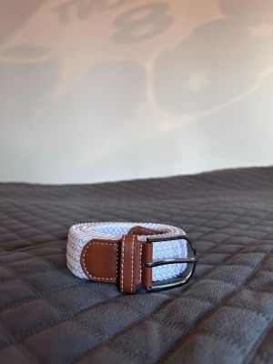 Vitt flätat bälte - Tja det är helt nytt från bältgallerian i storlek 105cm långt och 3,5cm brett. Det är gjort i ett elastiskt material och man kan anpassa längden vart man än vill. Om du inte gillar den här färgen finns flera andra att välja mellan. Desto mer du köper desto billigare blir det. Säljer också armband.