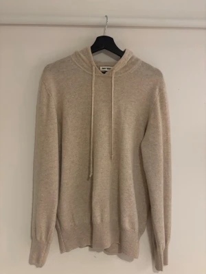 Soft Goat hoodie kashmir - Mysig beige hoodie från Soft Goat i mjuk kashmir. Klassisk modell med huva och dragsnören, ribbade muddar vid ärmslut och nederkant. Storlek M. Köpt på soft Goat butiken som tidigare låg vid Stureplan. Endast använd ett fåtal gånger. Nypris: 3995kr. Denna tröja är 100% Kashmir. 