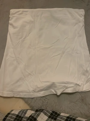 Vit tubtopp från Esmara - Säljer en enkel och stilren vit tubtopp från Esmara. Toppen är axelbandslös och har en rak passform som sitter snyggt på kroppen. Perfekt att matcha med jeans eller kjol för en clean look.