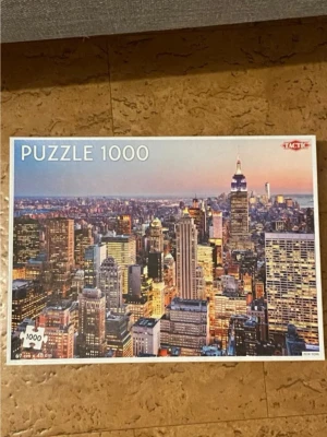Pussel 1000 bitar New York Tactic🧩💕 - Säljer ett pussel med 1000 bitar från Tactic som föreställer New Yorks skyline i solnedgång. Pusslet mäter 67 x 48 cm när det är färdigt och har färgstarka detaljer med stadens ikoniska byggnader. Perfekt för dig som gillar utmanande pussel och stadsmotiv.