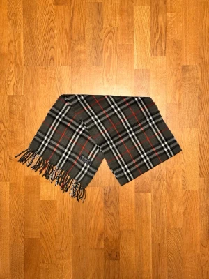 Grå Burberry halsduk - Säljer en grå halsduk från Burberry. Halsduken är i gott skick och är gjord i 100% kashmir. Var inte rädd för några frågor. Pris diskuteras inte!