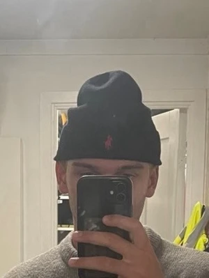 Svart mössa från Polo Ralph Lauren - Svart ribbstickad mössa från Polo Ralph Lauren med klassisk uppvikt kant och röd broderad logga framtill. Onesize 