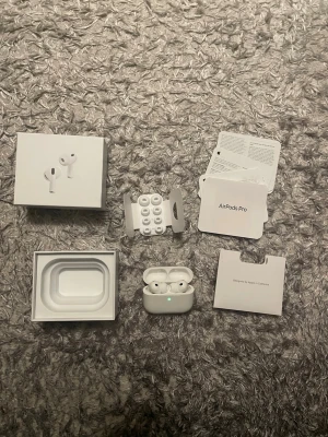 Apple AirPods Pro 3 trådlösa hörlurar - Säljer ett par vita Apple AirPods Pro med tillhörande laddningsetui och extra silikontoppar. Hörlurarna är in-ear och har en stilren, kompakt design i blank plast. Allt originaltillbehör och förpackning medföljer. Perfekta för musik, samtal och träning.