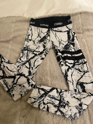Stronger leggings med marmormönster - Snygga leggings från Stronger med svartvitt marmormönster. Materialet är stretchigt och passar perfekt till träning eller chill. Det passar mig som har storlek S vanligtvis:)
