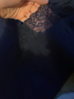 Mörkblå långärmad topp med spets - Mörkblå långärmad topp med v-ringning och dekorativ spetsdetalj vid halsringningen. Tunn och mjuk kvalitet. Knappt använda.