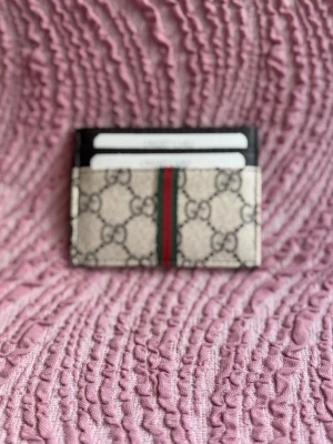  korthållare  - Svarta detaljer upptill och plats för flera kort. Perfekt accessoar för dig som gillar lyxiga detaljer och stilren design.