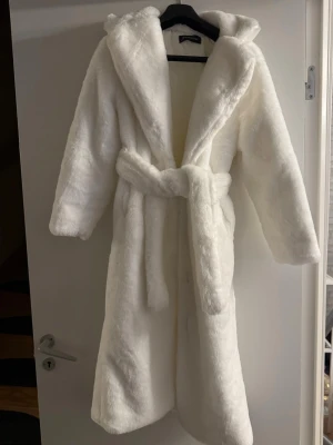 Vit fluffig jacka - Supermjuk och fluffig vit jacka, helt ny som tyvärr är för liten för mig. Perfekt nu inför vintern då den är sypermysig, extra lång modell som ger en lyxig känsla. Skulle säga att den passar en XS-S
