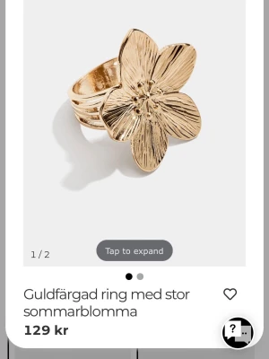 Guldfärgad ring med blomma - Snygg guldfärgad ring med en stor, detaljerad blomma som motiv. Ringen har en bred ringbas och blomman har fem blad med fina ingraverade linjer för extra effekt. Perfekt för dig som vill sticka ut med ett unikt smycke. Ringen är aldrig använd då jag inte använder guld. Ord pris är 129 kr hos glitter men säljer för endast 75 kr