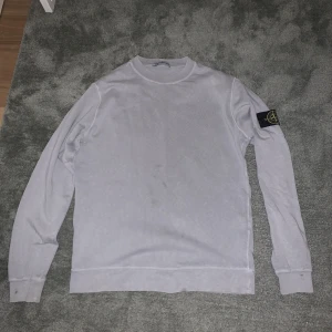 STONE ISLAND tröja - Säljer denna äkta stone island tröjan, storlek M. Den har en liten fläck på fram sidan och en liten fläck på baksidan men dem syns inte mycket, fråga för fler bilder.