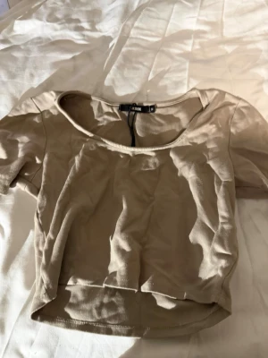 Beige croppad topp✨✨ - Säljer en beige croppad topp från Bik Bok i storlek M. Toppen har lite kortare ärmar en trekvarst ärmar och en u- ringad halsringning. Materialet är mjukt och stretchigt. Perfekt att styla vardagligt med jeans eller kjol för en chill look.✨