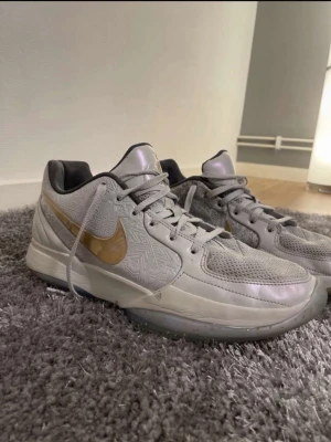 Ja 2 christmas - Säljer ett par ja 2 christmas basket skor med guld swoosh och mönstrad ovandel. Skorna har väldigt bra prestation på basket planen i alla kategorier. Skorna har snörning, mesh på tårna och detaljer i syntetmaterial. Yttersulan har ett unikt geometriskt mönster och transparent finish. Perfekt för dig som gillar sportig stil.