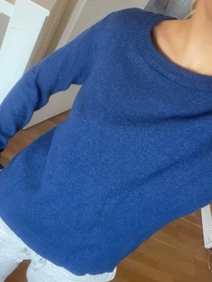 Blå stickad tröja från VILA - Snygg blå stickad tröja från VILA med rund halsringning och ribbade muddar vid ärmslut och nederkant. Tröjan har en enkel och klassisk design med lång ärm och är supermjuk. 