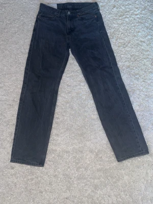 Svarta relaxed fit jeans från H&M - Svarta jeans från H&M med relaxed fit och klassisk femficksdesign. Modellen har rak siluett och normal midja, tillverkade i slitstarkt bomullsmaterial. Perfekt för dig som gillar en chill och loose stil. Storlek 30/34.