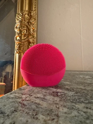 Foreo luna rosa - En rosa ansiktsrengöringsborste från Foreo i silikon med små mjuka piggar. Perfekt för att rengöra huden på djupet och ge en fräsch känsla. Rundad form som ligger skönt i handen och är enkel att använda i din hudvårdsrutin.