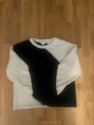 Svartvit stickad tröja Gina Tricot - Säljer en stickad tröja från Gina Tricot i storlek 158/164. Tröjan har ett coolt svart och vitt mönster i breda diagonala block, rund hals och långa ärmar. Materialet är mjukt och fluffigt, perfekt för kyliga dagar. Passar dig som gillar enkel men snygg stil.