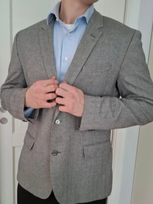 Kavaj från Hugo Boss - Säljer en riktigt stilig grå Hugo Boss Kavaj med måtten: Bredd-50, Längd-77cm, Storlek 54. Modellen i bild är 183cm, tycker kavajen passar de som är något större. Har du fler frågor skriv gärna! 