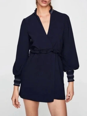 Byxdress från Zara med omlott - Blå byxdress från Zara i storlek M med lång ärm och snygga smockdetaljer vid hals och ärmslut. Omlott framtill och knyt i midjan ger en cool siluett. Materialet är mjukt och känns skönt mot huden. 