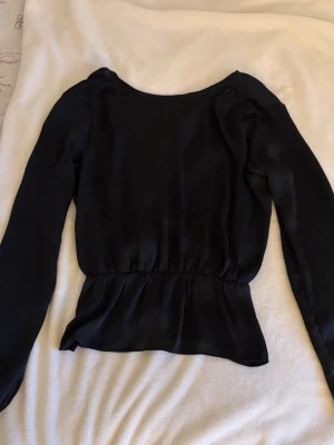 Svart blus - Svart blus som är öppen i ryggen.