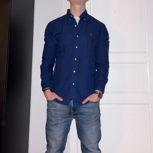 Mörkblå skjorta från Ralph Lauren - Mörkblå skjorta från Ralph Lauren i storlek M.  Fint skick till ett bra pris. Nypris: 1995kr. Mitt pris: 349kr. Vid frågor eller funderingar, tveka inte att höra av dig.
