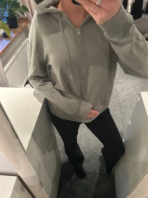 Grön hoodie  - En grön hoodie med dragkedja som aldrig är använd 