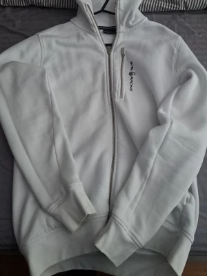 Vit Sail racing hoodie  - Vit Sail Racing hoodie i storlek M. Klassisk och stilren modell med sportig passform och hög kvalitet. Mjuk och bekväm på insidan, perfekt både till vardags och för en mer aktiv stil. Hoodien är i fint skick och väl omhändertagen.