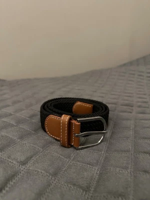 Svart flätat bälte - Tja det är helt nytt från Bältgallerian. Det är 105cm långt och 3,5cm brett. Det är i ett elastiskt material så passar större storlekar också. Om du inte gillar den här färgen så finns det många flera att välja mellan. Vid köp av bundle så blir kostnaden billigare.