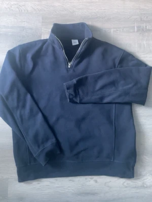 Mörkblå half zip tröja från Zara - Mörkblå långärmad tröja från Zara med half zip-dragkedja i halsen. Skön och enkel modell i bomull, perfekt till jeans eller över en t-shirt. Klassisk och stilren look som funkar året runt.