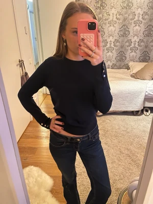 Marinblå stickad tröja med guldknappar - Så fin tunn långärmad stickad tröja, med guld knappar. Bara använd få gånger, inga defekter alls. Skriv gärna prisförslag!