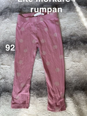 Rosa leggings med prickar, stl 92 - Säljer ett par rosa leggings med stora ljusa prickar. Byxorna har resår i midjan. Perfekta för en lekfull och bekväm stil till vardags.🌸 Mörkare på rumpa. Storlek 92