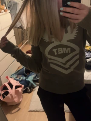 MET grön långärmad tröja - Detta är en gammal/vintage grön MET tröja. Tröjan är i storlek M, men passar fint på mig som vanligtvis har XS/S. Lite längre ärmar. Tröjan har inga hål eller andra skador, förutom en klippning vid bysten. Tröjan har fina jeans detaljer på ärmarna. Dessutom ett fint vitt fågel tryck.