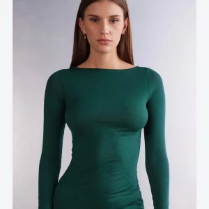 Mörkgrön långärmad topp - Snygg mörkgrön långärmad topp med rund halsringning och tight passform. Perfekt att styla med jeans eller kjol för en trendig look. Tunn och stretchig kvalitet som sitter skönt på kroppen.