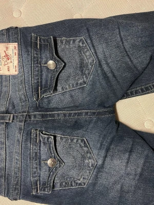 True Religion jeans  - Säljer nu mina fina true religion jeans strl 24 och ca 80 cm i innerbenslängd  i modellen joey low waist flare crystal!! Dessa säljs inte längre och är oerhört snygga med diamantdetaljer på sidorna. Tyvärr har några diamanter ramlat av (se sista bilden) men inget man tänker på när dom sitter på!💞