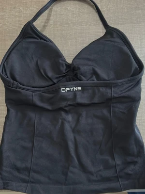 Svart linnetopp från DFYNE - Säljer en svart topp från DFYNE med halterneck och snygg rynkning vid bysten. Super fin till gymmet 🖤strl M men passar S. Helt oanvänd