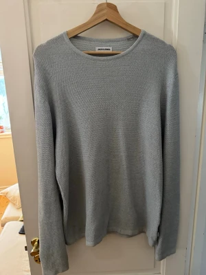 Ljusblå stickad tröja Jack & Jones - En stilren ljusblå stickad tröja från Jack & Jones i storlek S.(passar även M!) Tröjan har rund halsringning och lång ärm, perfekt för lager-på-lager. Mjuk och skön känsla med enkel design som funkar till många outfits.tröjan är i mycket bra skick förutom ett litet hål vid höger armhåla som man då ser på fjärde bilden!