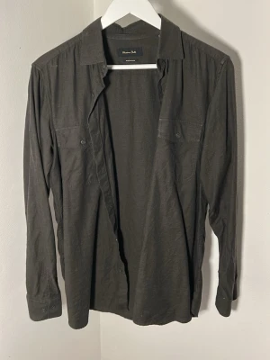 Skjorta från Massimo Dutti - Säljer min mörkgröna skjorta från Massimo Dutti. Skjortan är i storlek S men är ganska stor i passformen. Den är lite stor på mig och jag är 175 och väger ca 70 kg. Skicket på skjortan är mycket bra då den endast är använd ett fåtal gånger. En strykning så är du hemma!