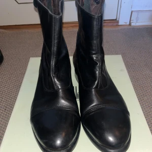 Svarta skinnboots från Billi Bi - Snygga svarta boots från Billi Bi i äkta skinn. Modellen har rund tå, låg klack och dragkedja baktill för enkel påtagning. Klassisk och stilren design som passar till många olika outfits. Perfekta för dig som gillar minimalistisk stil.