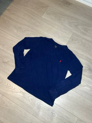 Ralph Lauren T-shirt, mörkblå, storlek L - Hej! Säljer nu denna blåa Ralph Lauren  T-shirten. Långärmad samt storlek L. Inga skador eller fläckar. Riktigt stilren och snygg T-shirt! Skickar alltid inom 24h efter köp🤩 Frågor om mått eller annat? Hör av dig!