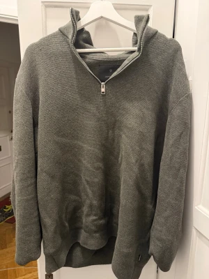 Grönmelerad half zip tröja från Jack & Jones - Säljer en grönmelerad långärmad tröja från Jack & Jones med half zip-dragkedja och hög krage. Tröjan är i mjukt stickat material och har en clean, avslappnad passform som funkar till allt. Perfekt för lager på lager under höst och vinter.