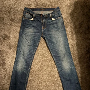  Nudie Jeans  - Snygga blå jeans från Nudie Jeans Co i storlek 32/32. Coola slitningar fram och bak!! 