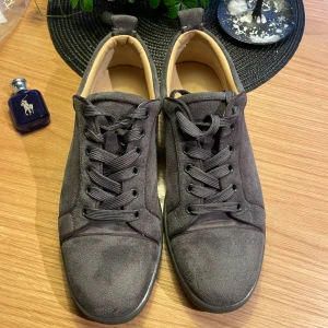 Grå loubs  storlek 40 -  grå  Loubs i mjuk mocka med klassiska röda sulor och rund tå. Skorna har gråa snören och platt sula, vilket ger en clean och stilren vibe. Perfekta för dig som gillar exklusiva detaljer och vill sticka ut med ikoniska röda undersidor. Hade kunnat sänka för en billig och  snabb affär