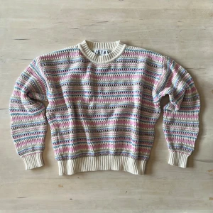 Randig stickad tröja från Stay XS - Säljer en mysig stickad tröja från Stay i storlek XS. Tröjan har ett randigt mönster i ljusa färger som beige, rosa, blå och grön. Rund halsringning och ribbade muddar vid ärmslut och nederkant. Perfekt för dig som gillar färgglada och chill vibes.