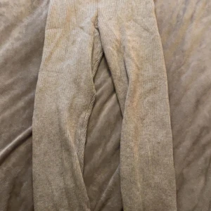 Beige ribbade stickade tights - Snygga beige stickade tights. Perfekta för dig som gillar en chill och stilren look. Byxorna har klassisk design utan synliga detaljer som knappar eller dragkedja. Passar till både sneakers och boots.